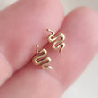 Load image into Gallery viewer, Teeny tiny Snake Studs in Bronze and Sterling silver between 2 fingers. Between 2 fingers by Studio Blue on Etsy
