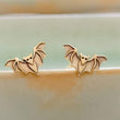 Load image into Gallery viewer, Golden bronze little bat studs on the rim of a sage green dish, by Studio Blue on Etsy