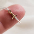 Load image into Gallery viewer, Tiny dagger charm necklace in Sterling silver with Bronze accent on a delicate silver chain by Studio Blue on Etsy.