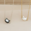 Load image into Gallery viewer, Mother of Pearl cat necklace. White or Black Mother of Pearl carved cat charm on delicate chain, sterling silver and 14k gold fill, by Studio Blue on Etsy