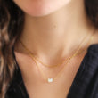 Load image into Gallery viewer, Mother of Pearl cat necklace. White Mother of Pearl carved cat charm on delicate chain shown with petite paperclip link chain on model