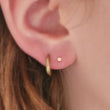 Load image into Gallery viewer, Tiny 2mm dot stud in solid 14k Gold, Screw in flat back nap in earrings on model by Studio Blue on Etsy