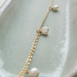 Load image into Gallery viewer, White Baroque pearl drops on delicate 14k gold fill chain, shown on a light green background, by Studio Blue on Etsy