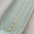 Load image into Gallery viewer, Dainty shimmer chain in 14k gold fill on sage green, oblong ceramic dish by Studio Blue on Etsy