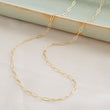 Load image into Gallery viewer, Dainty paperclip link chain necklace shown in 14k gold fill, shown draped on a light green oblong ceramic dish and beige background. By Studio Blue on Etsy
