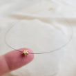Load image into Gallery viewer, Golden Pyrite Star necklace on black filament, shown on index finger by Studio Blue on Etsy