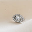 Load image into Gallery viewer, Titanium Evil Eye earring stud with pavé set clear CZ's around a clear, marquise shaped CZ in the center on a cream background byStudio Blue on Etsy
