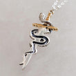Load image into Gallery viewer, Back view of the Snake &amp; Dagger Necklace pendant showing the black outline
