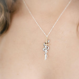 Model wearing the Snake & Dagger Necklace without birthstone accent, displaying the pendant’s balanced design and refined edge against a simple neckline for everyday statement wear.