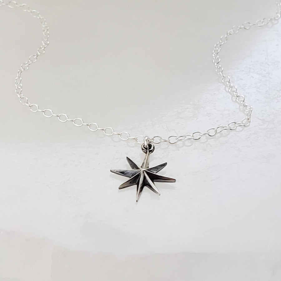 North Star, Starburst pendant in sterling silver on cable chain, on white background. By Studio Blue on Etsy