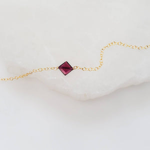 Dainty square cut Garnet bracelet on 14k gold fill cable chain on white background by Studio Blue on Etsy