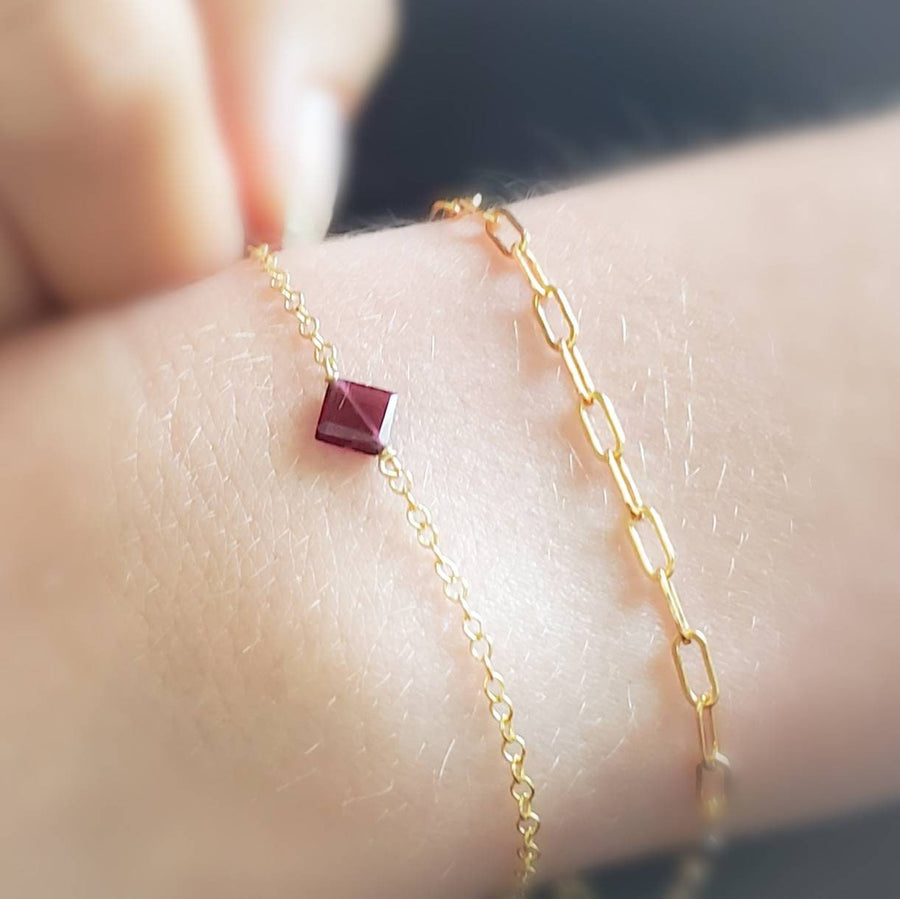 Dainty square cut Garnet bracelet on cable chain, accompanied by a small paper clip link bracelet on model by Studio Blue on Etsy