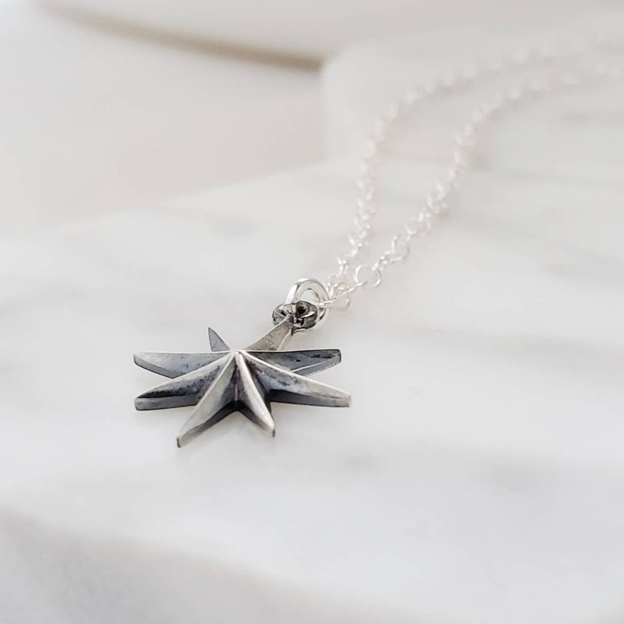 North Star, Starburst pendant in sterling silver on cable chain, on white background. By Studio Blue on Etsy