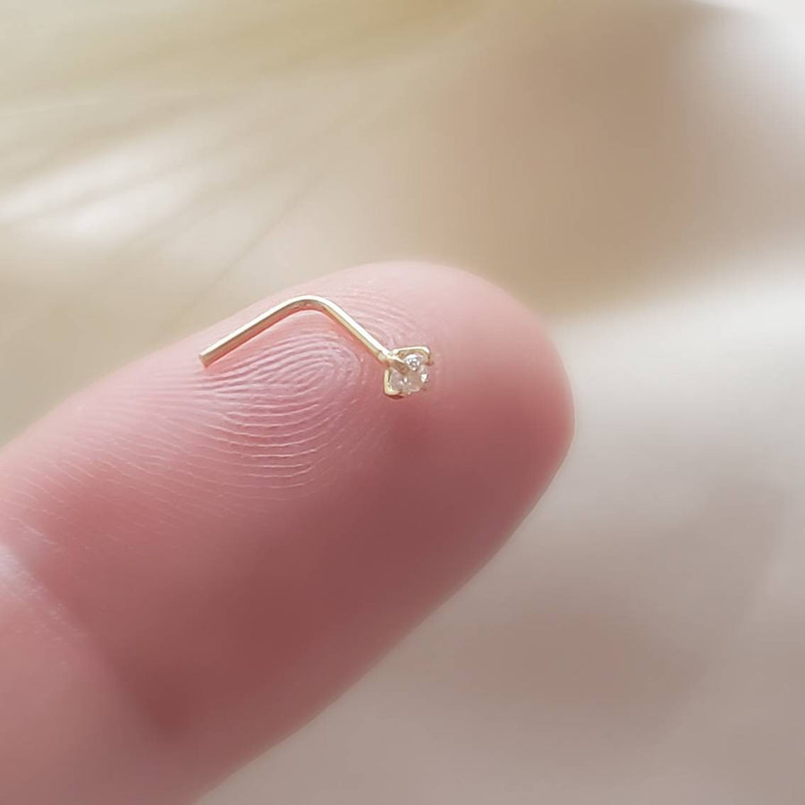 14K Gold and 2mm Diamond CZ nose stud shown in L-Bend style, 22 gauge, on a finger by Studio Blue on Etsy