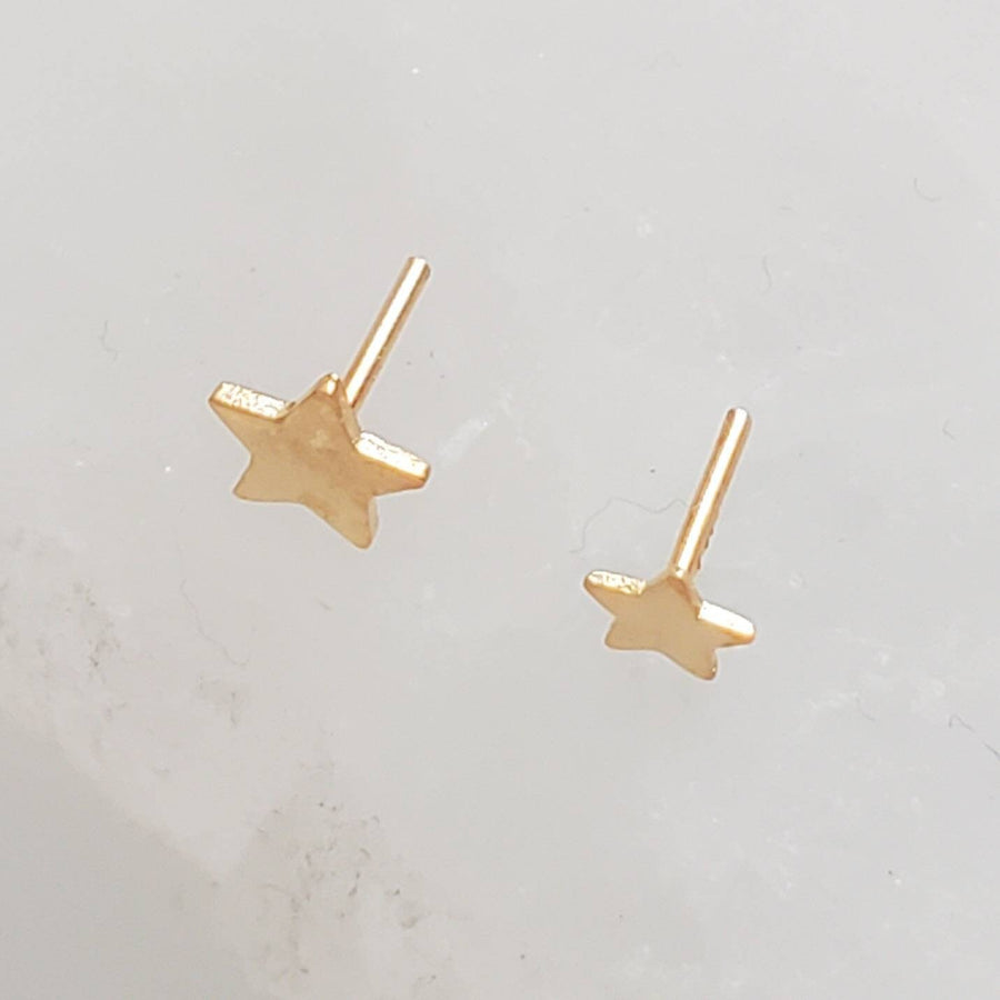 Solid 14K Gold Star studs, overhead shot of the 3mm and 4mm top post side by side on white background by Studio Blue on Etsy