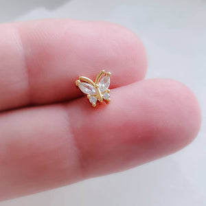 Diamond CZ Butterfly studs in 14k Gold plated 316L Surgical steel between 2 fingers. Screw-in, flat-back nap studs by Studio Blue on Etsy