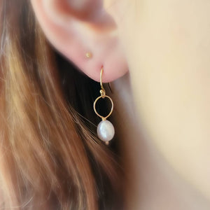 White, oval freshwater pearl drop earrings featuring a delicate open hoop in 14k Gold fill shown on model, by Studio Blue on Etsy