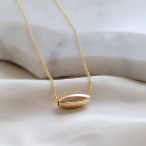 Gold fill oval bead floating on a dainty chain, on a light background, by Studio Blue on Etsy