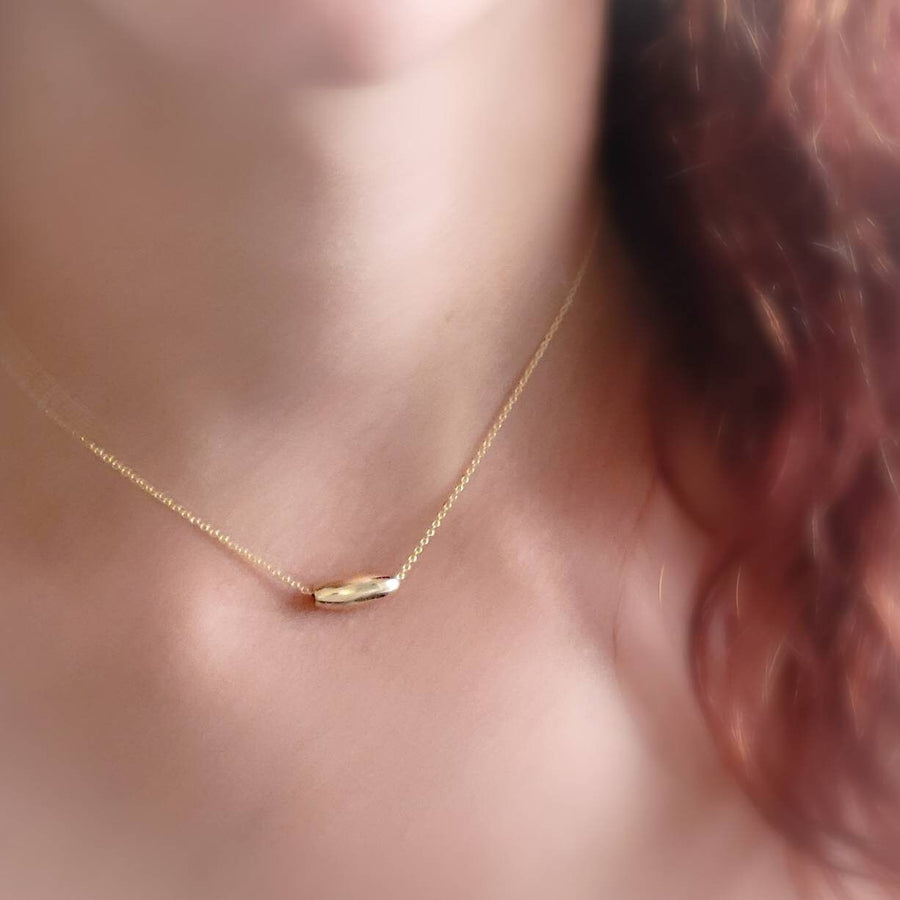 Gold fill oval bead floating on a dainty chain, on model, by Studio Blue on Etsy