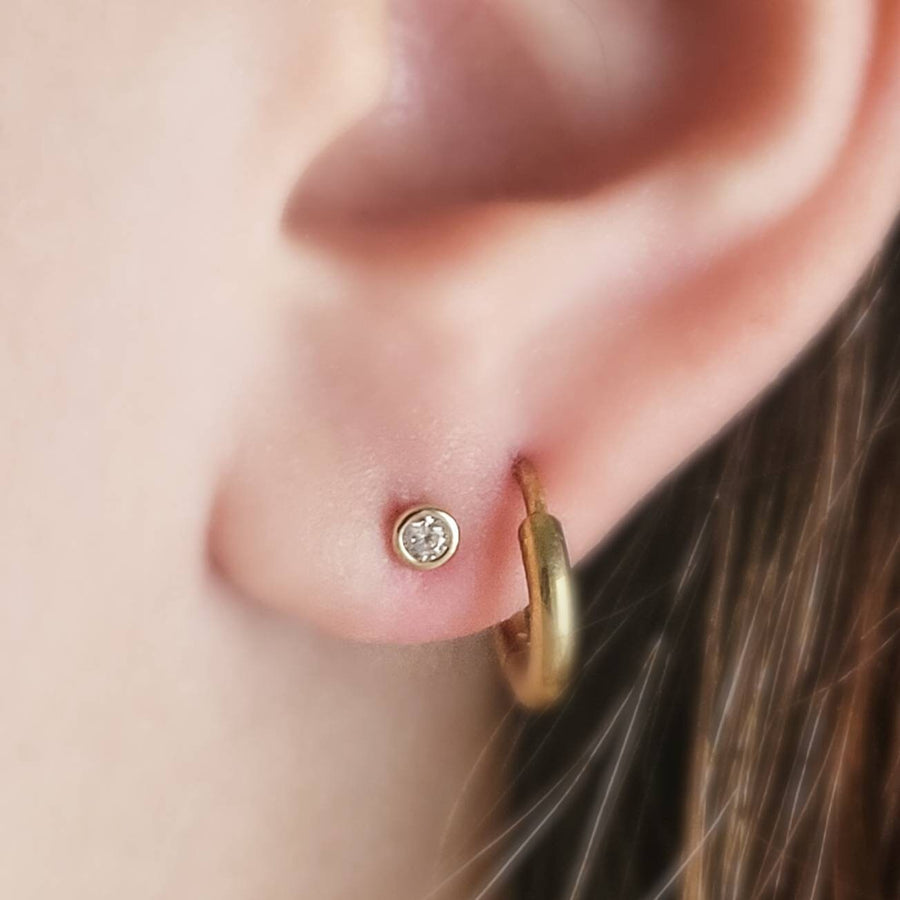 14 karat gold and cubic zirconia push in flat back studs modeled on ear