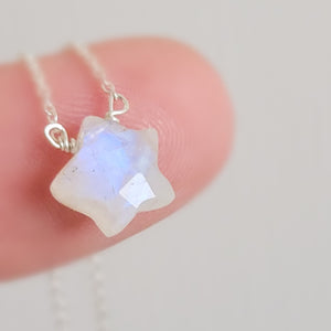 Gemstone star necklace in Rainbow Moonstone with sterling silver chain on finger, by Studio Blue on Etsy