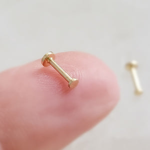 Tiny 2mm dot studs in solid 14k Gold, Screw in flat back nap in earrings on finger by Studio Blue on Etsy