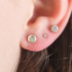 Sterling silver Sand Dollar stud earrings shown on model&#39;s ear, by Studio Blue on Etsy