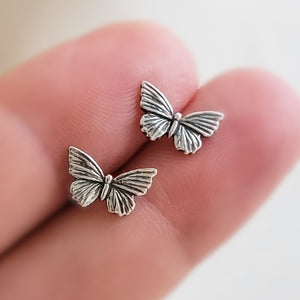 Sterling silver Butterfly studs earrings shown on two fingers by Studio Blue on Etsy