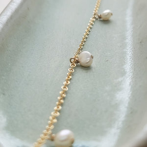 White Baroque pearl drops on delicate 14k gold fill chain, shown on a light green background, by Studio Blue on Etsy