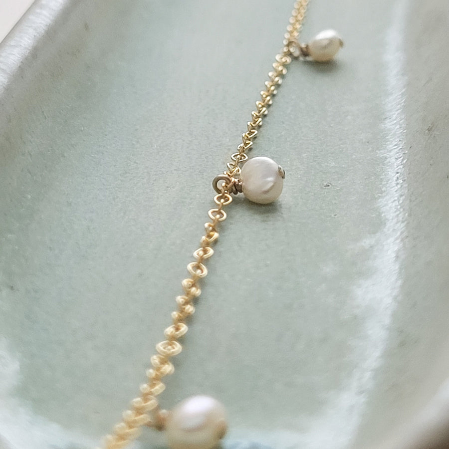 White Baroque pearl drops on delicate 14k gold fill chain, shown on a light green background, by Studio Blue on Etsy