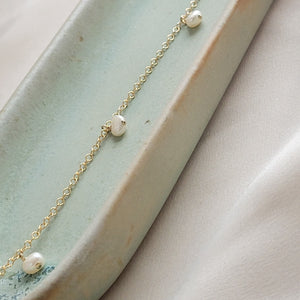 White Baroque pearl drops on delicate 14k gold fill chain, shown on a light green background, by Studio Blue on Etsy