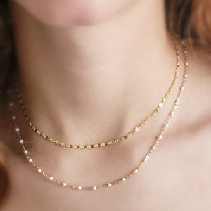 Dainty shimmer chain shown in 14k gold fill along with a longer 14k gold fill chain dotted with white enamel beads by Studio Blue on Etsy