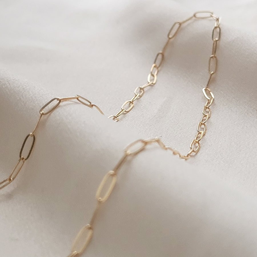 Dainty paperclip link chain necklace in 14k gold fill, on beige fabric. By Studio Blue on Etsy