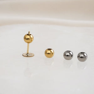 Two pairs of Titanium Ball backs with silicone center, one pair in silver, one pair in 14k gold plate. One single ball back shown with a stud earring on white background, by Studio on Etsy