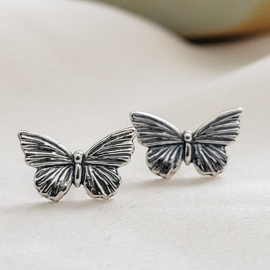 Pair of Sterling silver Butterfly studs earrings shown on white background by Studio Blue on Etsy