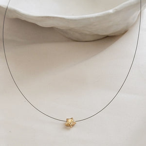 Golden Pyrite Star necklace on black filament, shown on white background by Studio Blue on Etsy