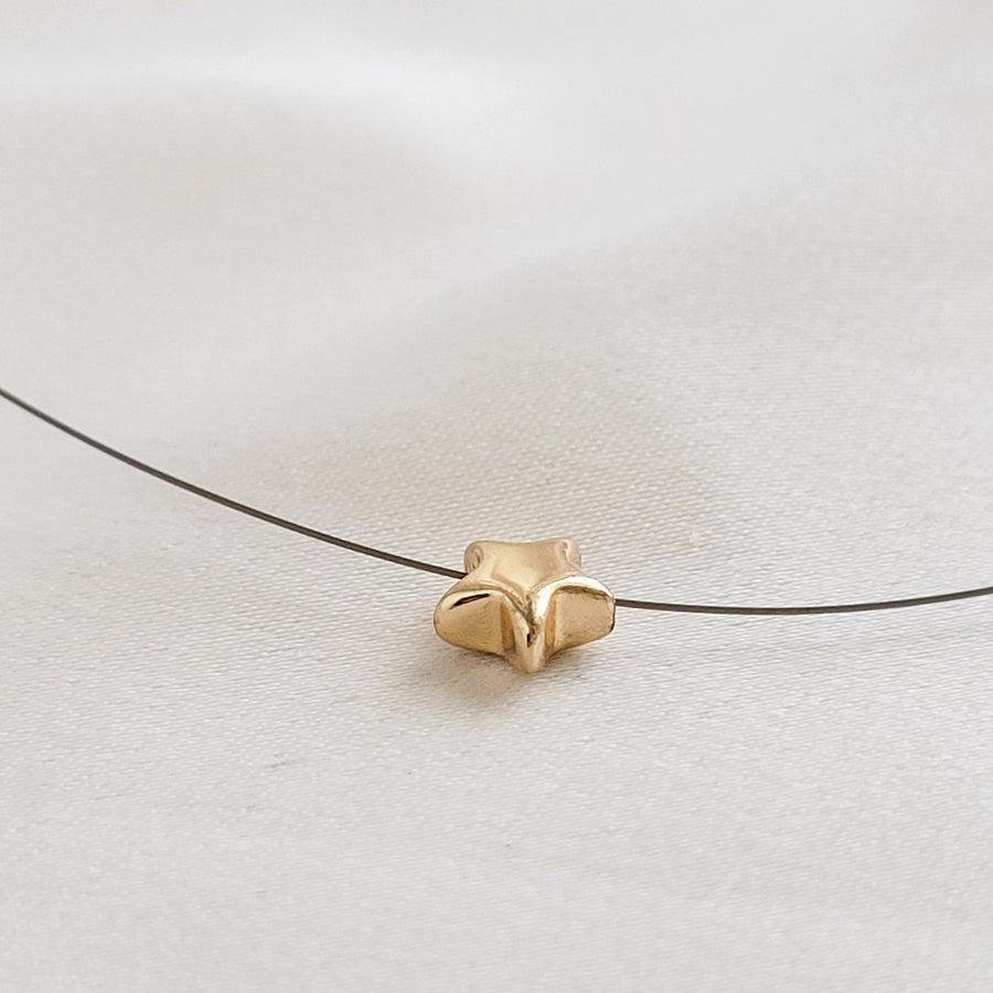 Golden Pyrite Star necklace on black filament, shown on white background by Studio Blue on Etsy