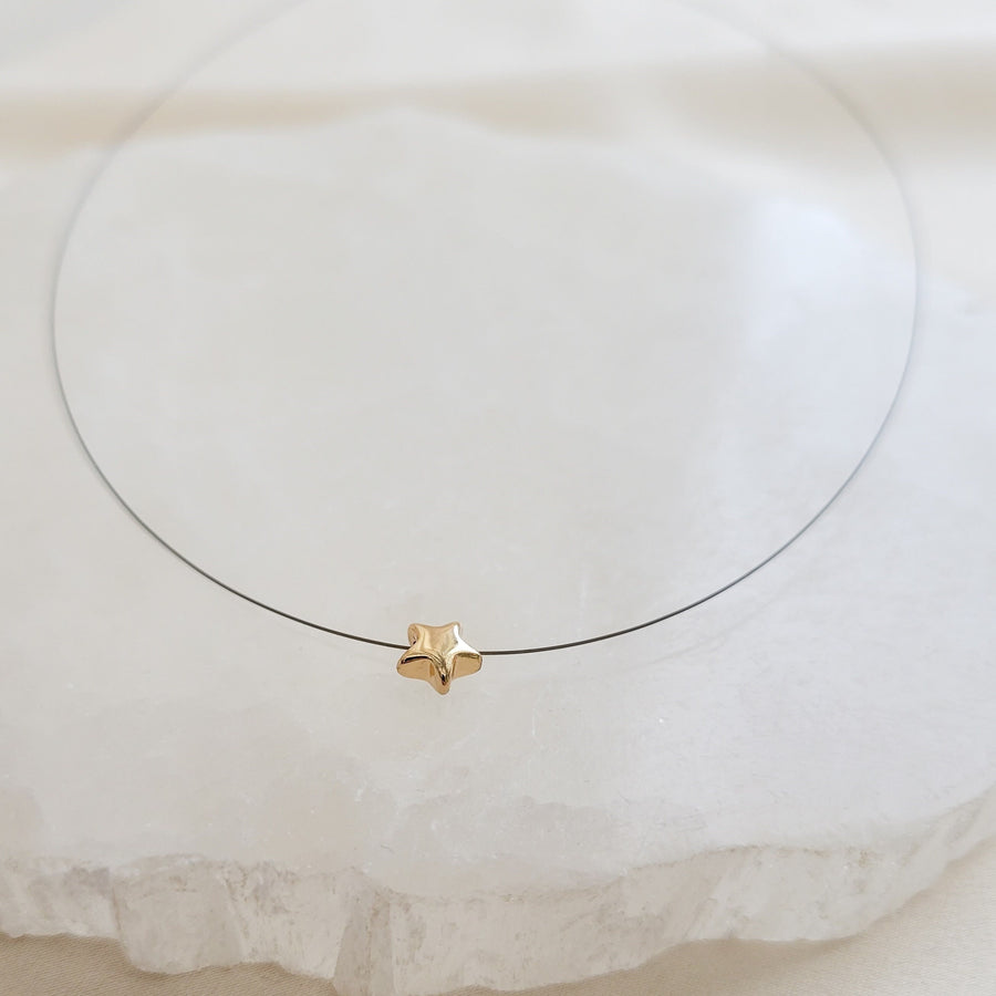 Golden Pyrite Star necklace on black filament, shown on white background by Studio Blue on Etsy