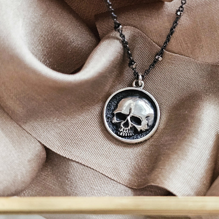 Sterling silver Skull medallion with an oxidized, dotted silver chain, on brown ribbon. By Studio Blue on Etsy