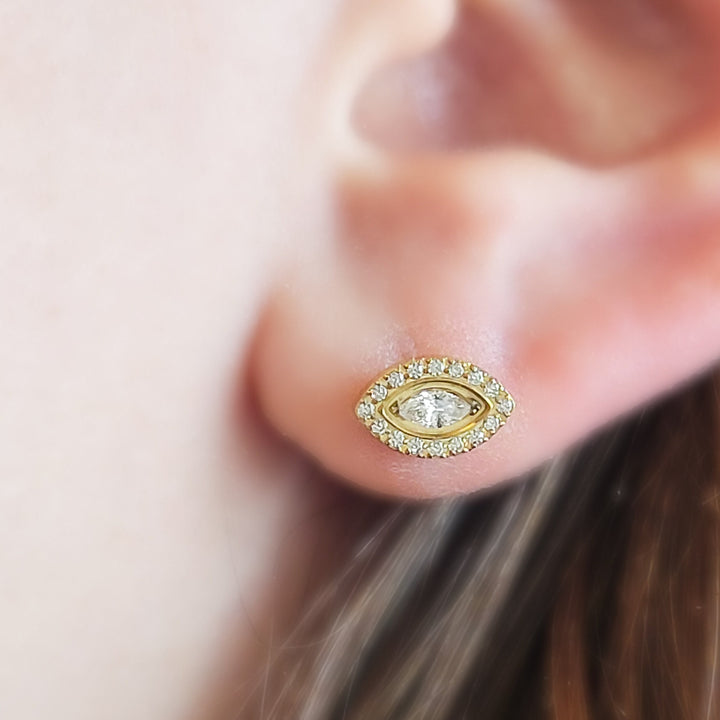 Gold plated Titanium Evil Eye earring stud shown on ear. By Studio Blue on Etsy