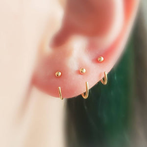 3 yellow gold open huggie hoops with 2mm ball beads on ear