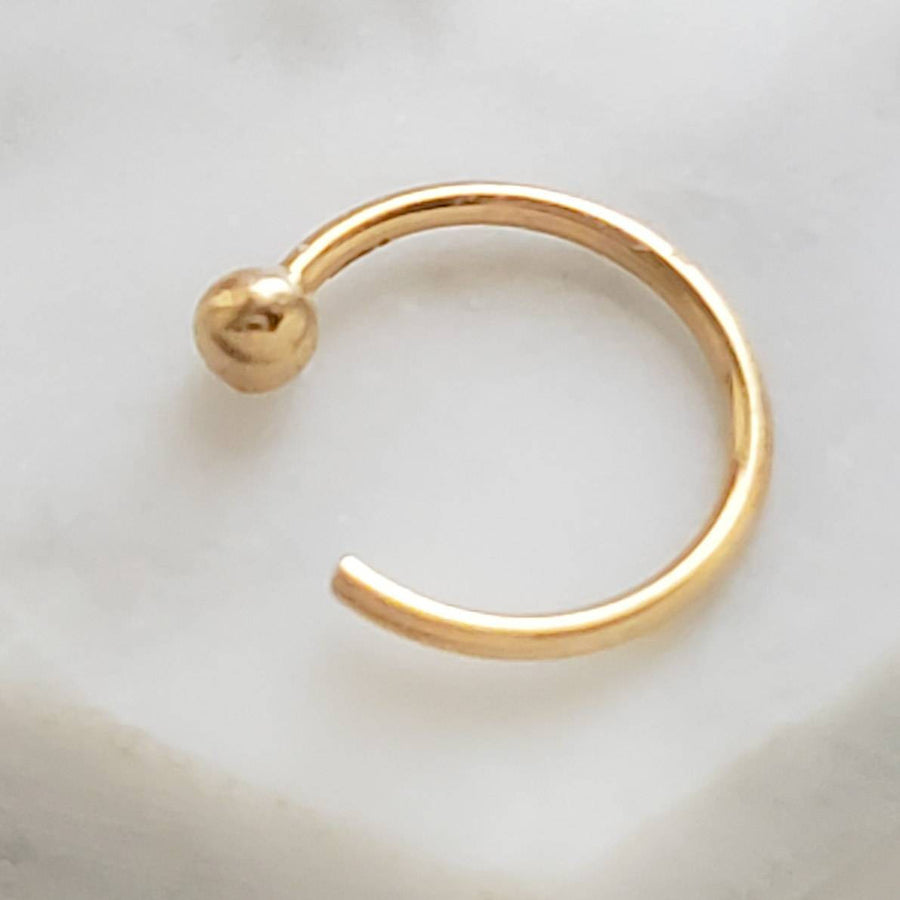 Yellow gold open hoop  with 2mm ball bead marked 14k  on white background